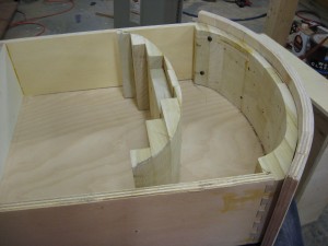The front of drawer box is the base of a laminated block that allows cutting a match to the drawer front curvature.